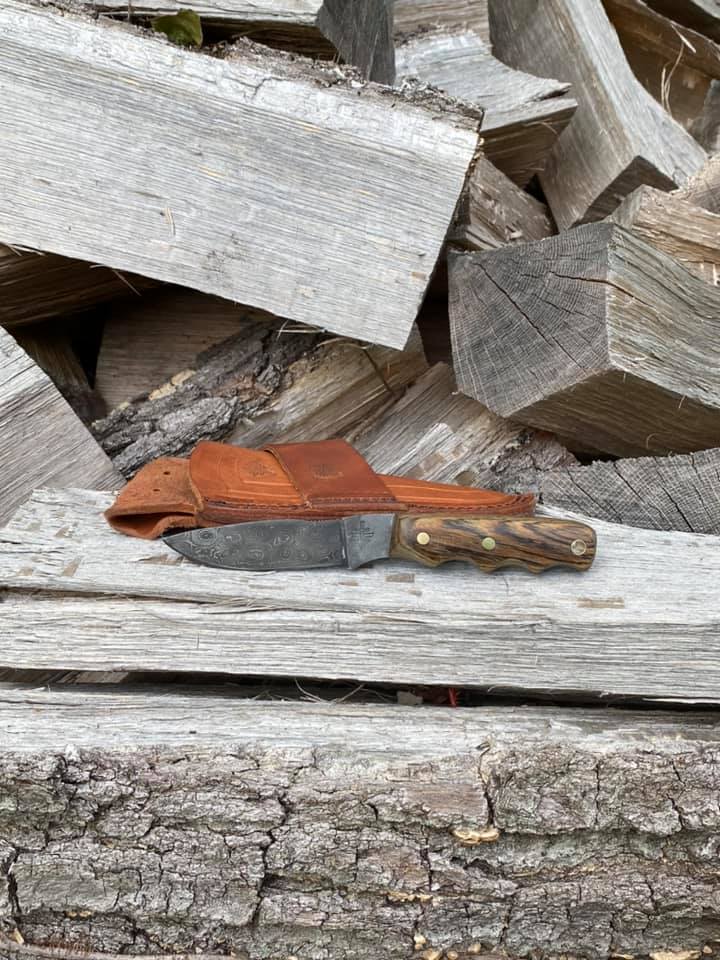 Alaskan hunter bush knife on wood pile